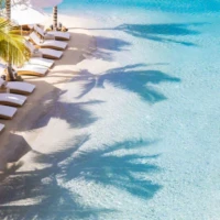 Beach chairs line large commercial sand pool