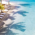 Beach chairs line large commercial sand pool