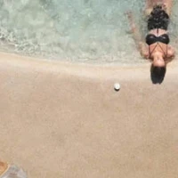 woman lies by shore of sand pool